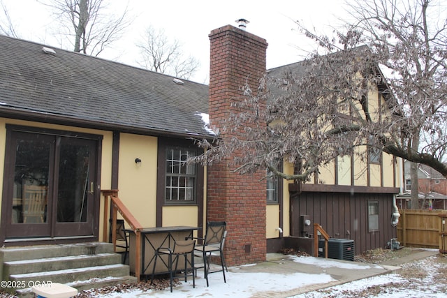 snow covered back of property with cooling unit