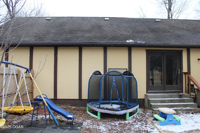 snow covered house with a trampoline