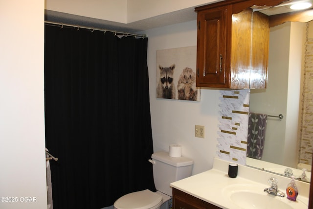 bathroom with toilet, vanity, and a shower with shower curtain