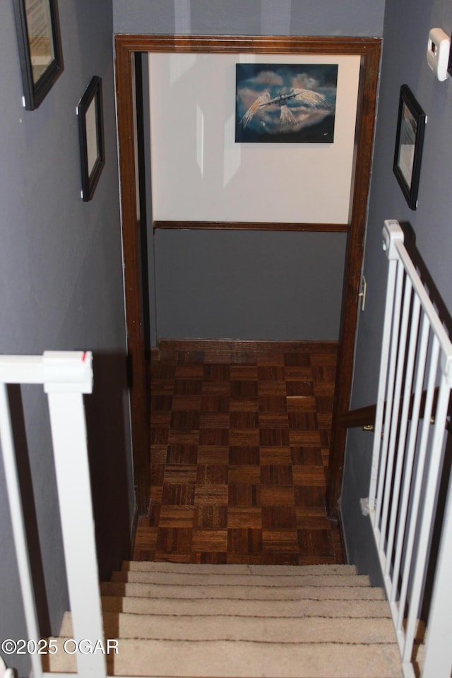 staircase featuring parquet flooring