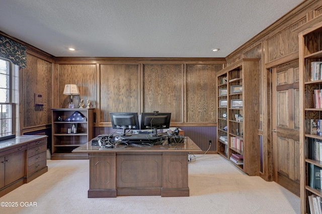 carpeted home office featuring a textured ceiling and wood walls