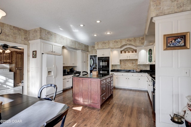 kitchen with white cabinetry, dark hardwood / wood-style floors, an island with sink, and black appliances