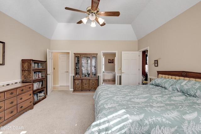 bedroom featuring vaulted ceiling, light colored carpet, ceiling fan, and ensuite bathroom