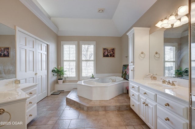 bathroom featuring vanity, vaulted ceiling, and a relaxing tiled tub