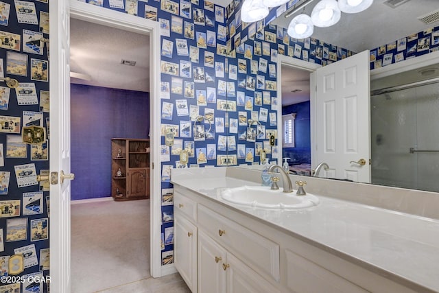 bathroom featuring tile patterned flooring, vanity, a textured ceiling, and walk in shower