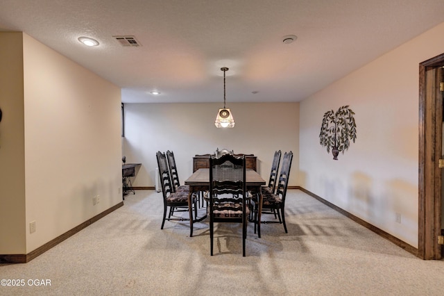 carpeted dining space featuring a textured ceiling