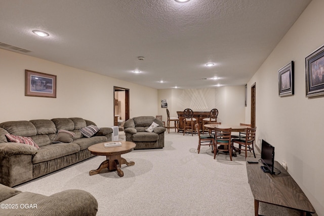 living room with light colored carpet, a textured ceiling, and bar area