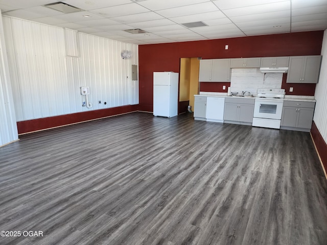 kitchen with white appliances, dark wood-type flooring, a paneled ceiling, electric panel, and sink