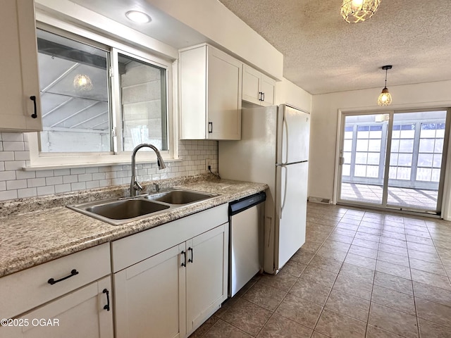 kitchen with dishwasher, white cabinetry, decorative backsplash, sink, and hanging light fixtures