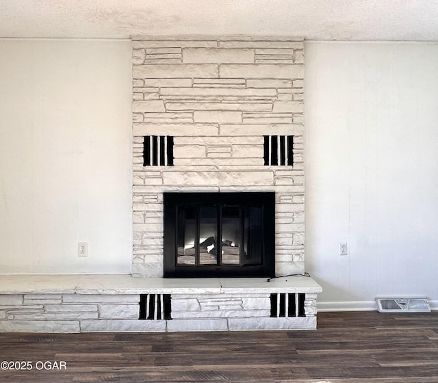 room details with a textured ceiling, hardwood / wood-style floors, and a fireplace