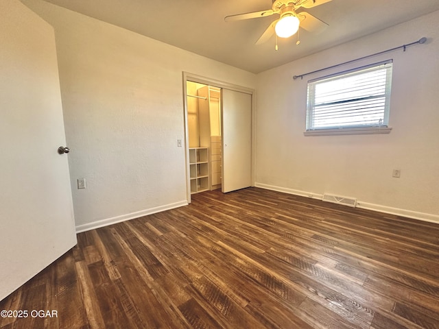 unfurnished bedroom with ceiling fan, a closet, and dark hardwood / wood-style flooring