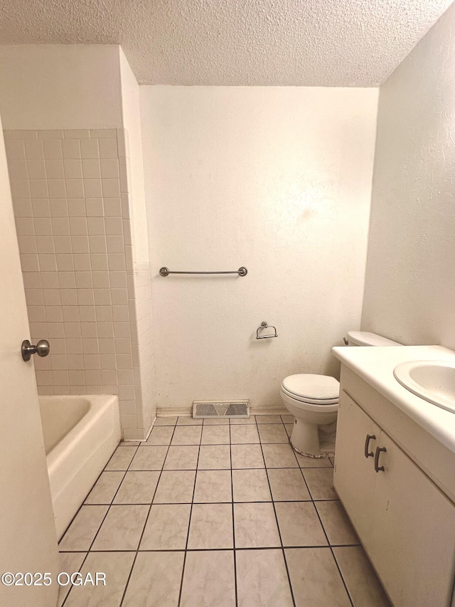 full bathroom with tile patterned floors, toilet, vanity, and a textured ceiling