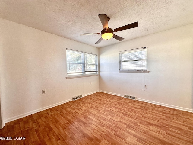 unfurnished room featuring ceiling fan, a textured ceiling, and light wood-type flooring