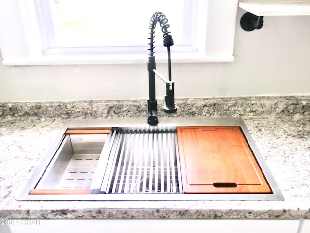 room details featuring white cabinets and sink