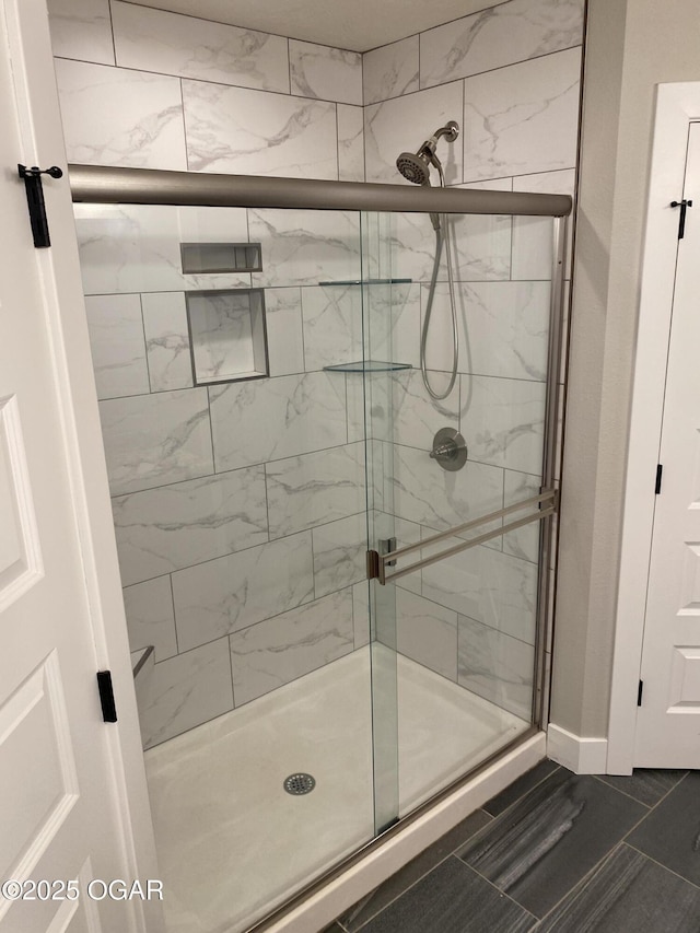 bathroom with tile patterned flooring and an enclosed shower