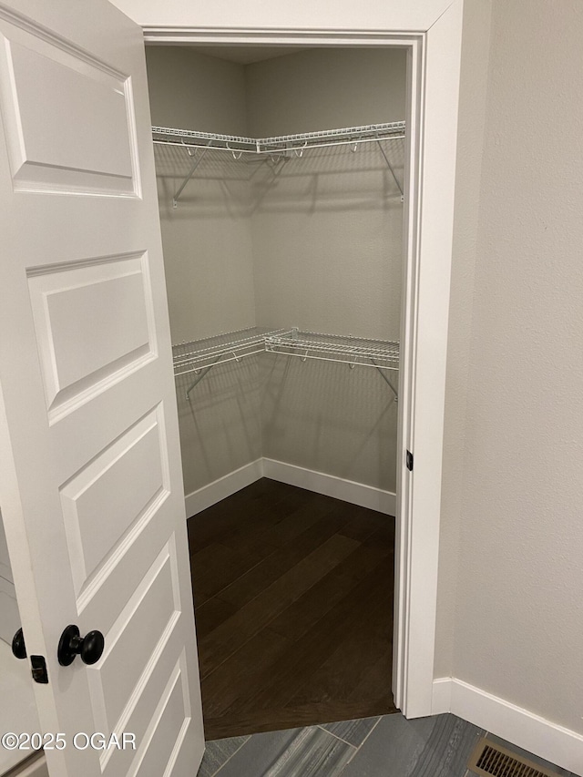 spacious closet with dark hardwood / wood-style floors