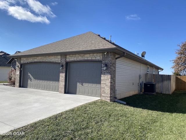 view of side of home featuring a garage, central AC unit, and a lawn