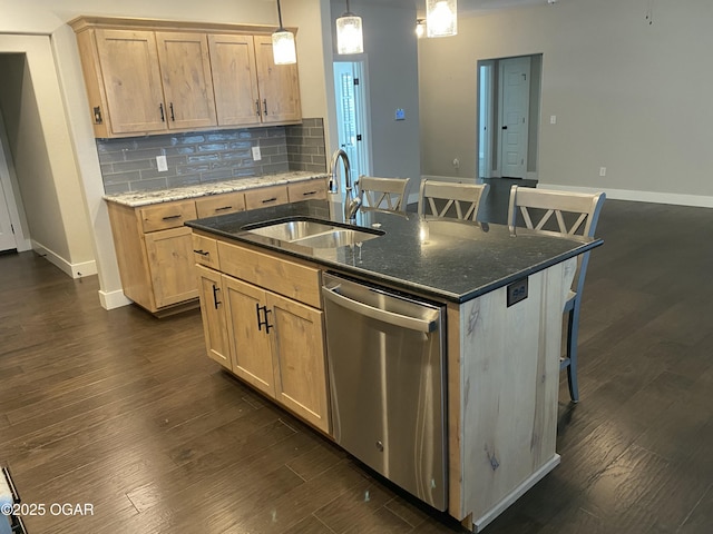 kitchen featuring sink, light brown cabinets, stainless steel dishwasher, an island with sink, and dark stone counters