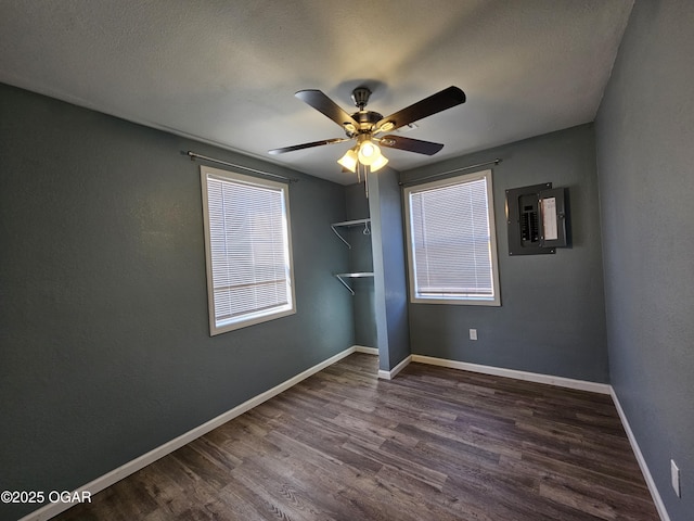 spare room featuring ceiling fan, dark hardwood / wood-style flooring, and electric panel