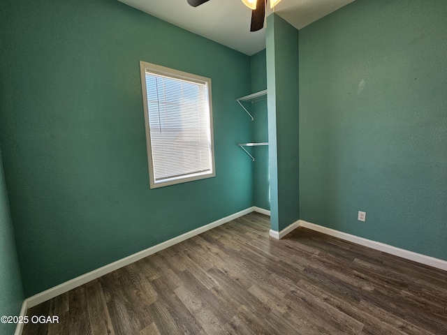 empty room featuring dark wood-type flooring and ceiling fan