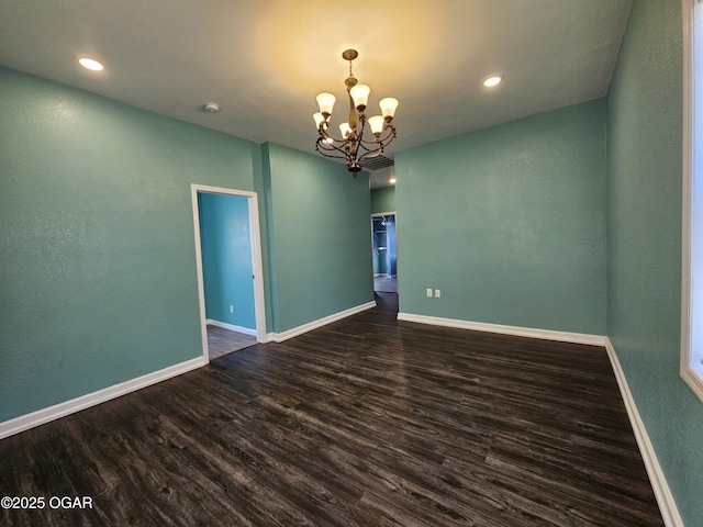 unfurnished room featuring dark wood-type flooring and a notable chandelier