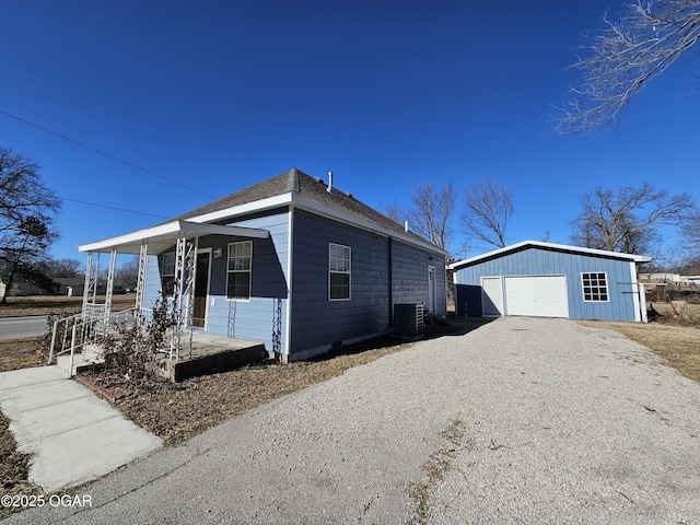 view of front of house featuring a garage, an outbuilding, central AC unit, and covered porch