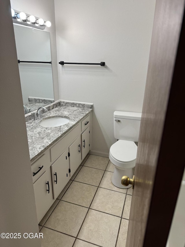 bathroom with tile patterned flooring, vanity, and toilet