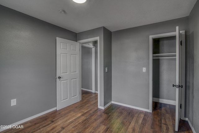 unfurnished bedroom featuring dark wood-type flooring and a closet