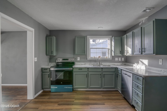 kitchen featuring appliances with stainless steel finishes, dark hardwood / wood-style flooring, sink, and a textured ceiling