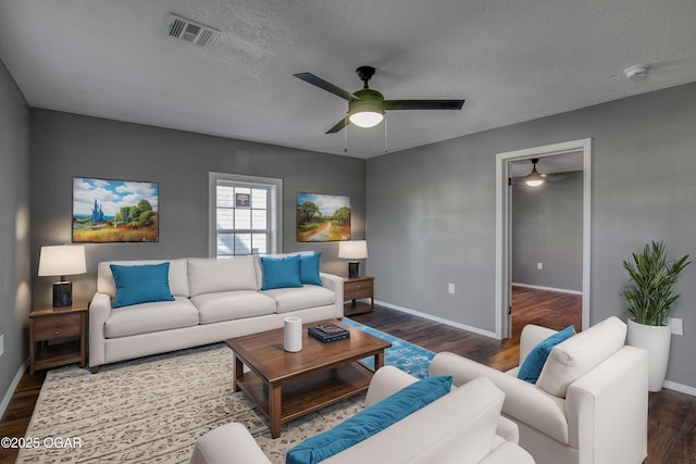 living room featuring ceiling fan, a textured ceiling, and dark hardwood / wood-style flooring