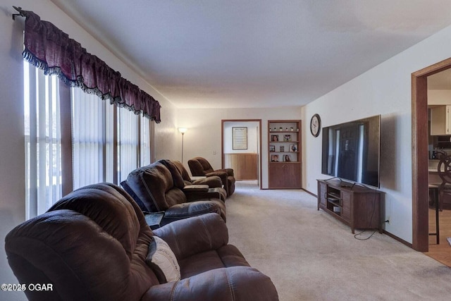 living room featuring light colored carpet and built in features