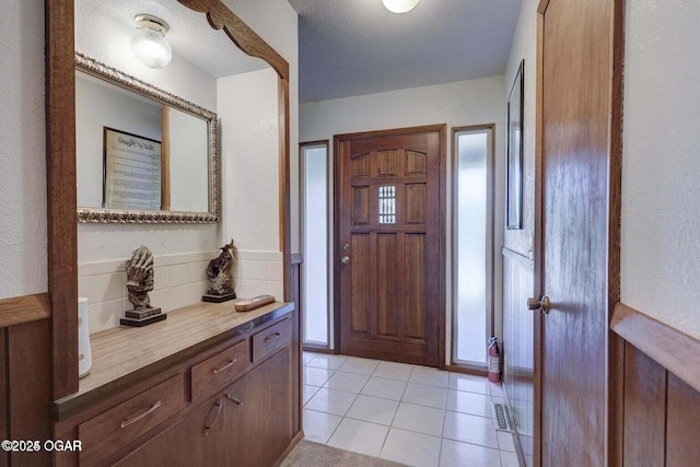 tiled foyer entrance featuring a textured ceiling