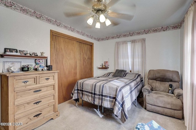 bedroom with ceiling fan, a closet, and light carpet