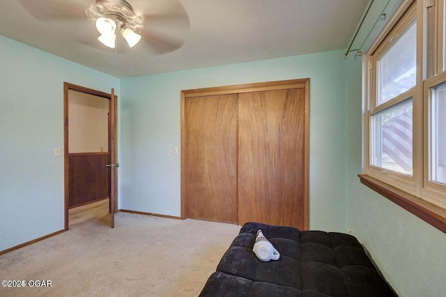 bedroom featuring light carpet, a closet, and ceiling fan