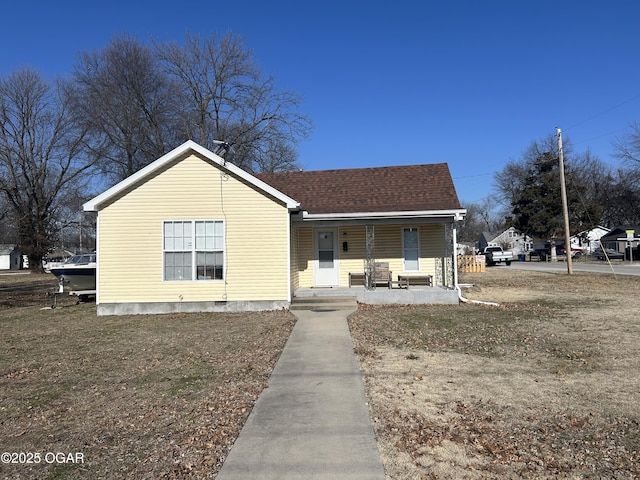 bungalow featuring covered porch and a front lawn