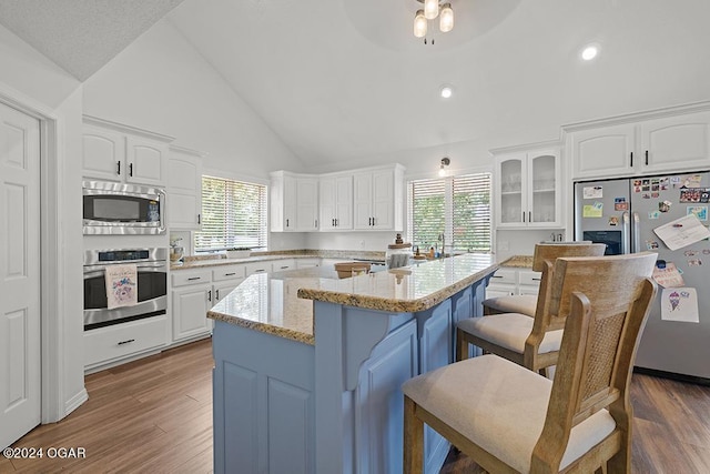 kitchen featuring appliances with stainless steel finishes, a breakfast bar area, a kitchen island, and white cabinets