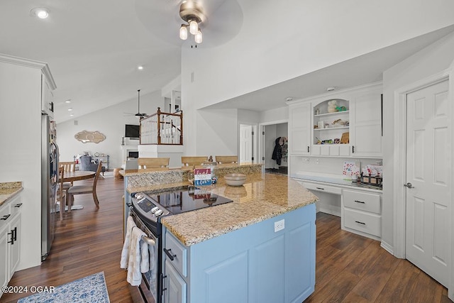 kitchen with vaulted ceiling, white cabinets, light stone counters, ceiling fan, and stainless steel appliances