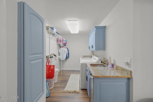 laundry room featuring sink, cabinets, separate washer and dryer, a textured ceiling, and dark hardwood / wood-style flooring