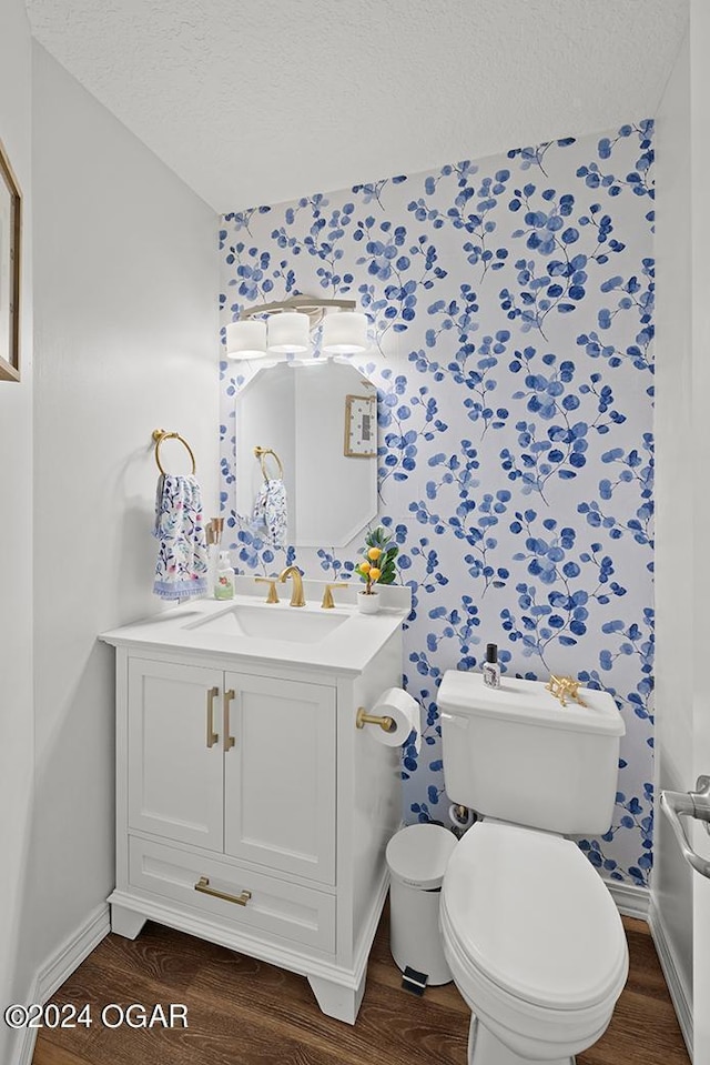 bathroom with wood-type flooring, vanity, a textured ceiling, and toilet