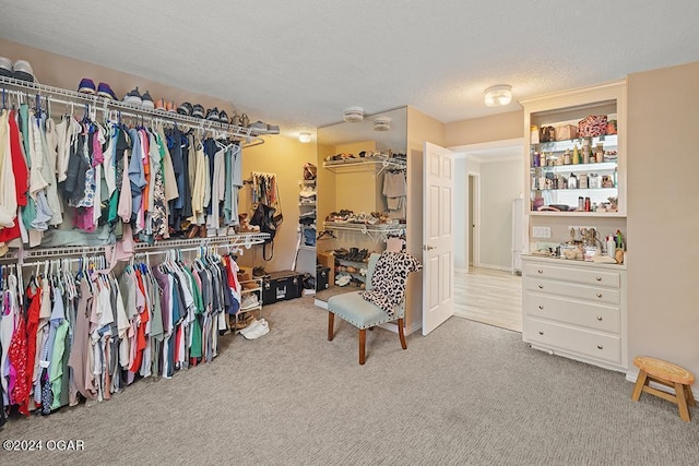 walk in closet featuring light carpet