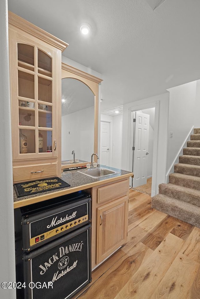 kitchen featuring dishwasher, sink, light brown cabinetry, and light hardwood / wood-style floors