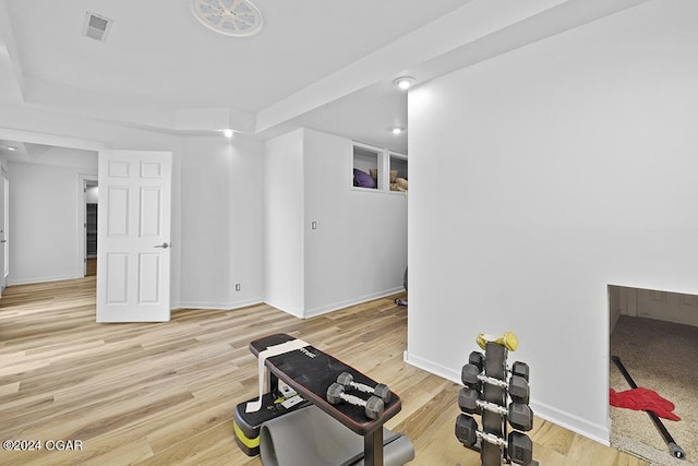 exercise room with light wood-type flooring