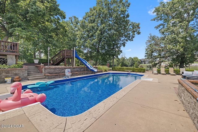 view of pool with a patio, a diving board, and a playground