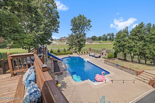 view of swimming pool with a playground, a deck, and a patio area