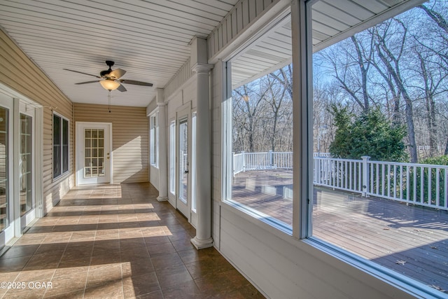 unfurnished sunroom with ceiling fan