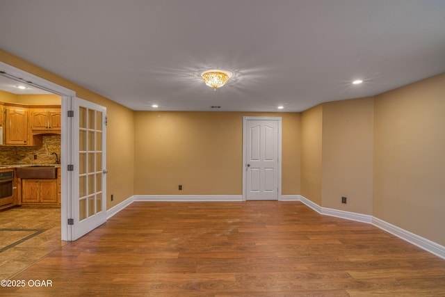 unfurnished room with sink and light hardwood / wood-style floors