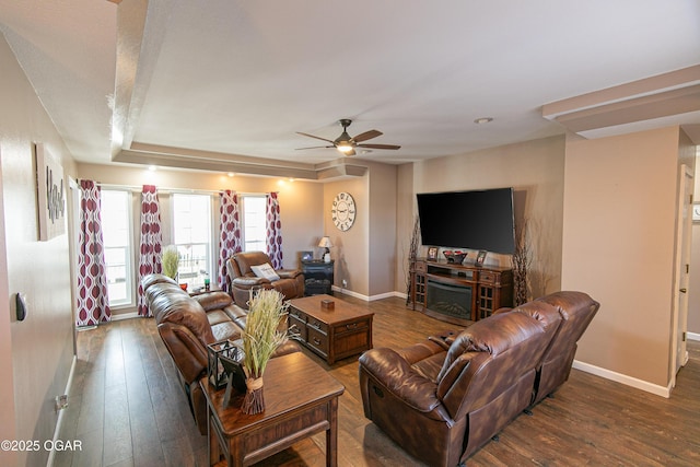 living room with dark wood-type flooring, a fireplace, and ceiling fan