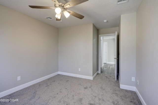 empty room with light carpet, a textured ceiling, and ceiling fan