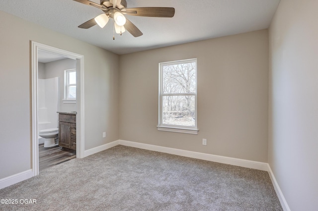 carpeted spare room featuring ceiling fan