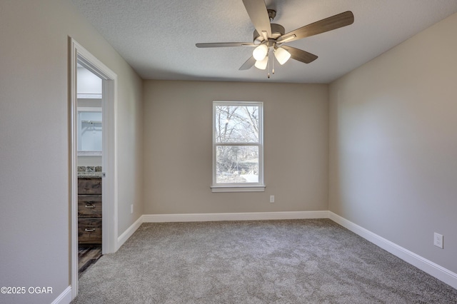 carpeted spare room with ceiling fan and a textured ceiling